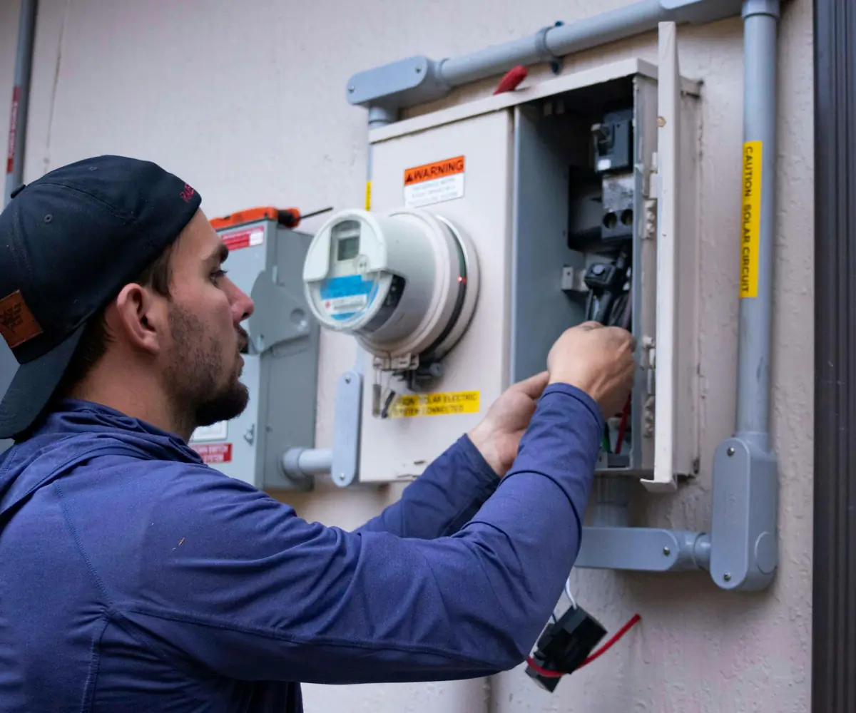 Licensed electrician working on a home's electrical meter and panel